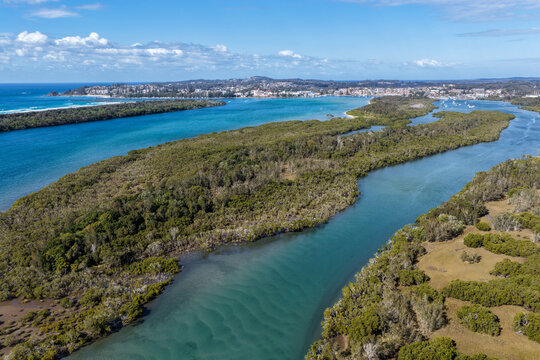 Aerial view from Settlement Point looking along the Hastings River towards Port Macquarie, showcasing the broad waterway, foreshore, surrounding coastal landscape and urban area in the distance 