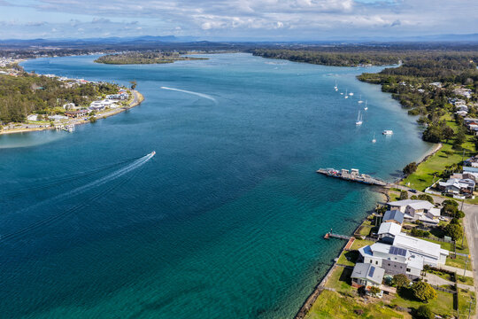 Aerial view of the Settlement Point Ferry crossing the Hastings River in Port Macquarie, connecting Settlement Point with the northern side of the river amid the scenic waterways and coast