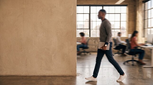 Businessman Walking with Laptop in Modern Open Plan Office