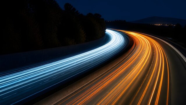 Night highway long exposure with dual color light trails on curved asphalt road