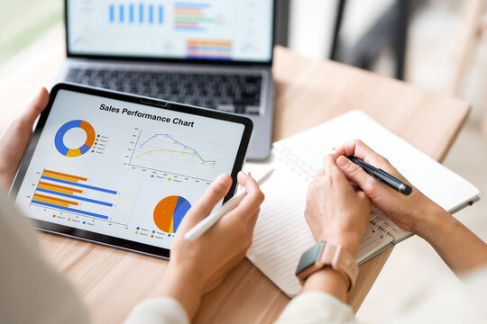 Close Up Business People Holding Digital Tablet and Writing Notes in Office