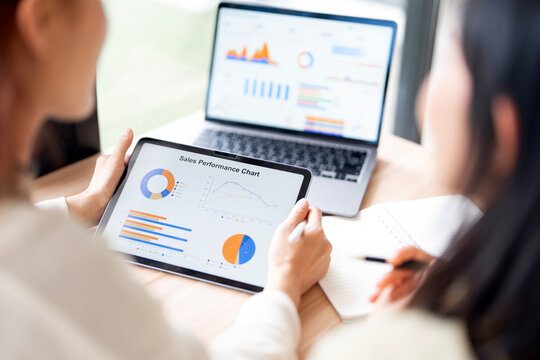 Close Up Business People Holding Digital Tablet Displaying Sales Performance Chart in Office