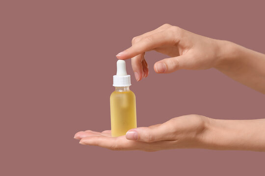 Skincare and beauty product concept, womans hands holding a dropper bottle with serum or oil, natural cosmetics and wellness
