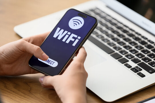 Wireless internet connection and digital communication, person connecting to wifi on smartphone with laptop