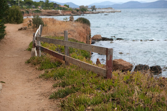 rocky seashore and a wooden fence in the foreground