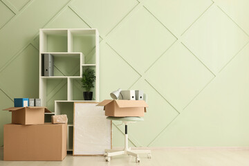Office relocation and business move, cardboard boxes with office supplies and furniture in a new empty room © Pixel-Shot