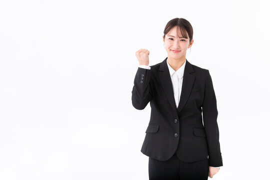 ガッツポーズをするスーツの若い女性