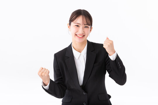 ガッツポーズをするスーツの若い女性