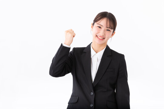 ガッツポーズをするスーツの若い女性