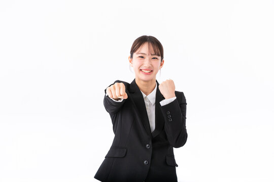 ガッツポーズをするスーツの若い女性