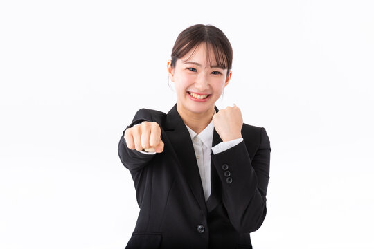 ガッツポーズをするスーツの若い女性