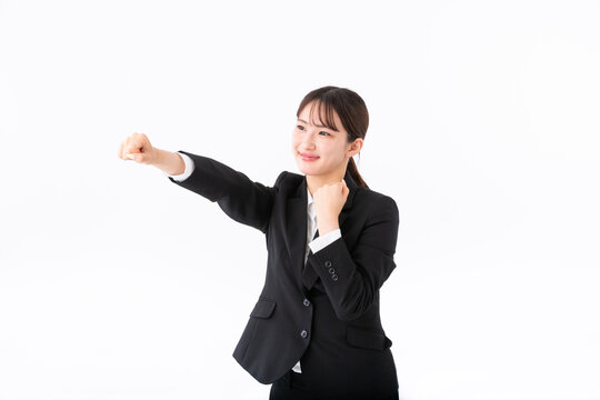 パンチをするスーツの若い女性
