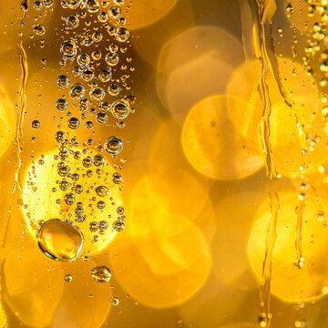 Golden liquid with rising bubble, glowing bokeh, and warm abstract texture creating luminous celebratory background for firefly new year concept use