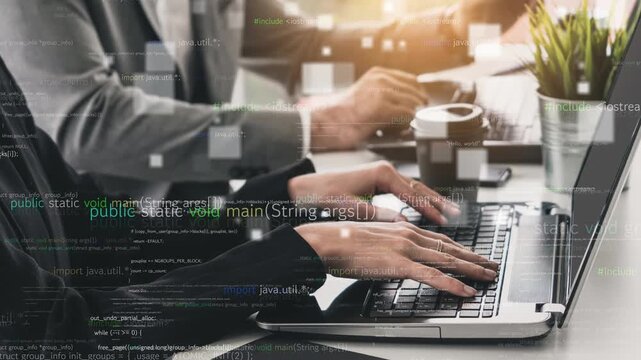 Close-up view of hands typing on a laptop keyboard in a modern office. Coding overlays create a high-tech atmosphere while professionals engage in collaborative software development. Xenic