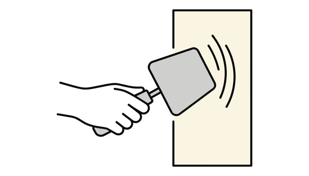 Hand holding a gray contactless card close to a sensor reader on a light yellow wall to gain access or pay.