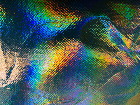 Abstract metallic holographic texture background with colorful iridescent spectrum and grid pattern.