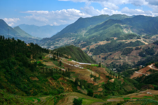 Stunning aerial view of vibrant green rice terraces in Sapa, Vietnam. A world-famous landmark featuring breathtaking natural landscapes and traditional agricultural beauty. 