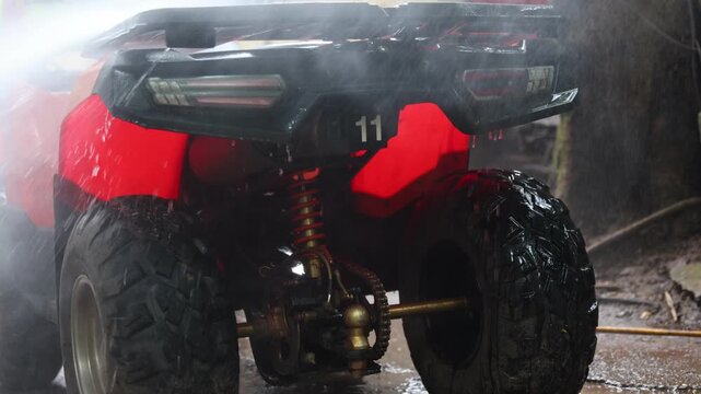 Red All Terrain Vehicle Quad Bike Outdoor Off Road Adventure on Wet Forest Trail with Rugged Tires, Visible Suspension, Underbody Detail, Dramatic Misty Lighting, and Adventurous Mood