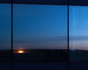 Fototapeta premium Dark glass curtain wall with a soft navy blue sheen and a warm golden light reflection, creating a quiet corporate background for overlays