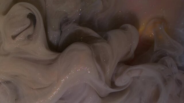 Shiny ink drop. Underwater fume. Blur purple blue yellow color wet glitter cloud splash acrylic liquid spreading on abstract background.