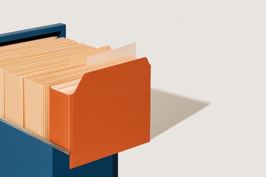 A single orange file folder stands out from a row of manila folders in a blue drawer, featuring textured card stock for estate planning and wealth management, with copy space