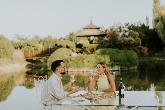 Romantic outdoor dining experience by the serene water at sunset
