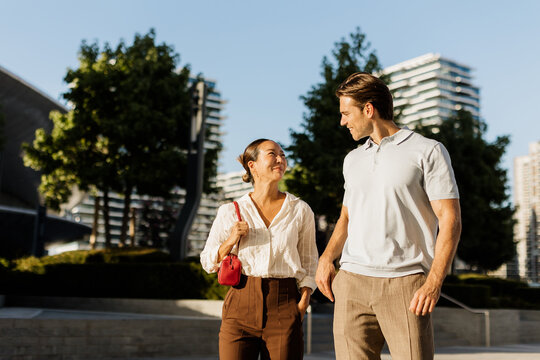 Couple enjoys a sunny day walking in a modern urban park