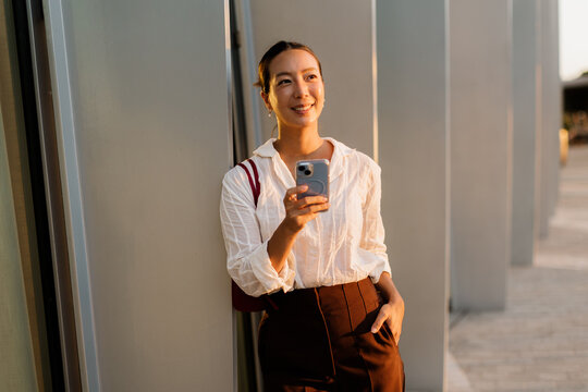Korean woman enjoys golden hour while taking a casual selfie