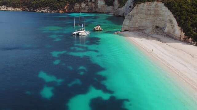 Anchored sailing boats in turquoise bay by white cliffs on Fteri beach, Kefalonia island in Greece