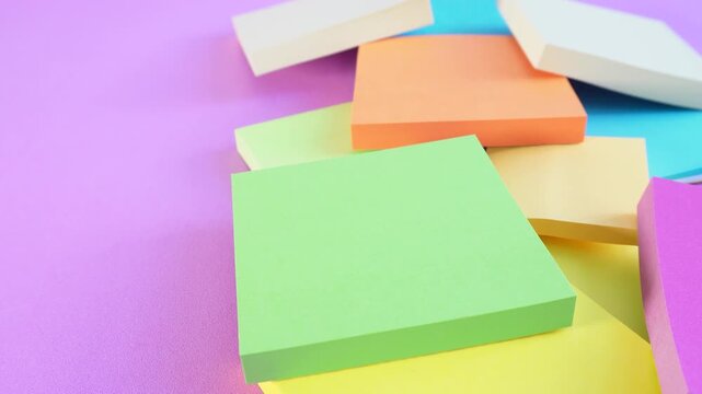 Stacked colorful sticky notes on soft purple surface