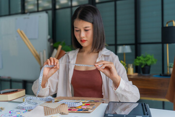 Asian woman designer using measuring tape measure cloth © Wanda