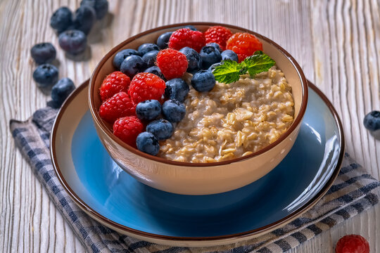 Sch&auml;lchen mit eingeweichten Haferflocken und belegt mit Himbeeren und Blaubeeren
