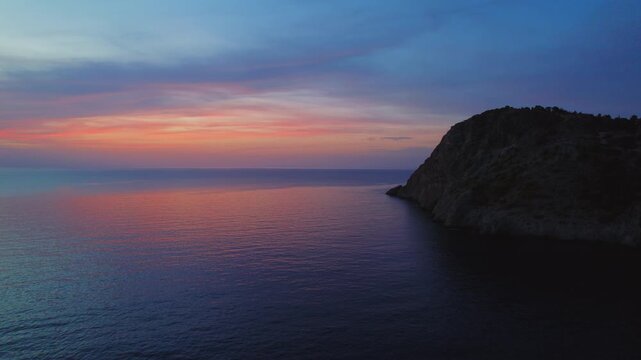 Sunset view over rocky coastline on a calm summer evening
