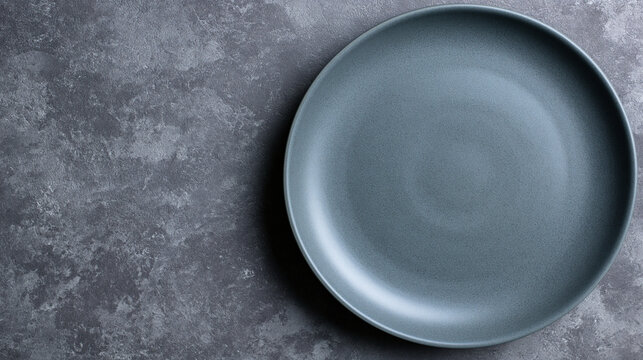 Empty dark grey ceramic plate on textured stone surface background with slate background
