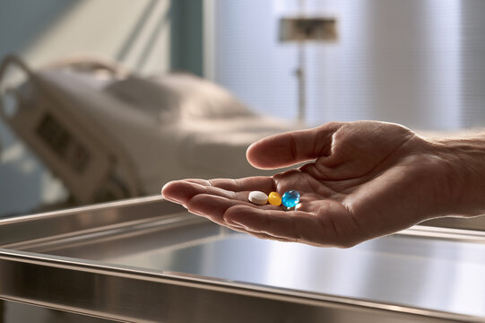 open hand holding three daily medication pills