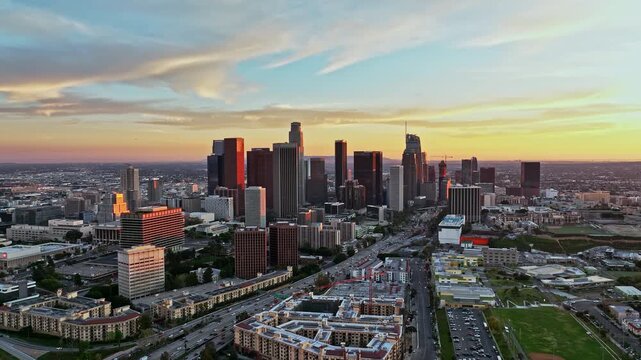 LA skyline with traffic roads. City of LA in sunset. Dramatic sky above LA skyline. Los Angeles towers at sunset. Sunset over California city. Skyscrapers in Los Angeles.