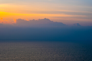 Fototapeta premium nature sky breathtaking golden sunset over a calm ocean, with the entire sky and water bathed in brilliant shades of yellow and orange. Streaky clouds enhance the dramatic display 
