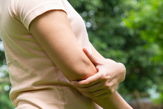 A woman has pain in his elbow and tendon muscles and he relieves the pain with a massage. Health and healing concept	