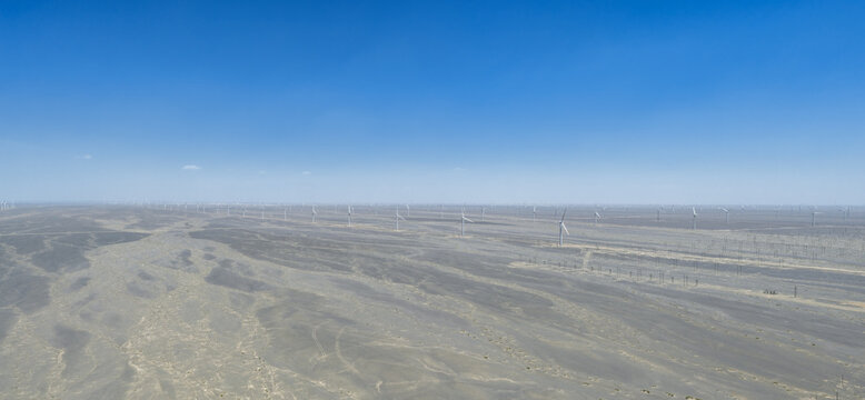 Vast Wind Farm Array Across Arid Gobi Desert Landscape Under Blue Sky