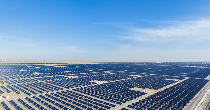Endless Rows of Solar Panels Stretching Across Desert Under Blue Sky