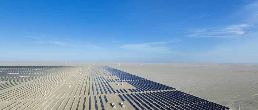 Aerial Panorama of Expanding Desert Solar Power Farm Under Blue Sky