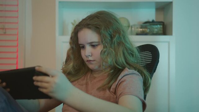 Gamer kid portrait. Kid gamer looking at the screen. Gaming at home. Kid using a game console. Child gaming online. Gamer concentration on screen. Teenager player gaming console.