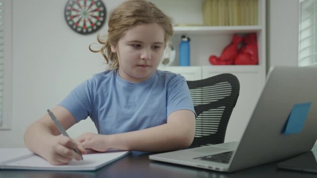 Child working on laptop indoors. Child watching educational content on laptop. Child focused on laptop learning. Child studying online with laptop. School kid study online.