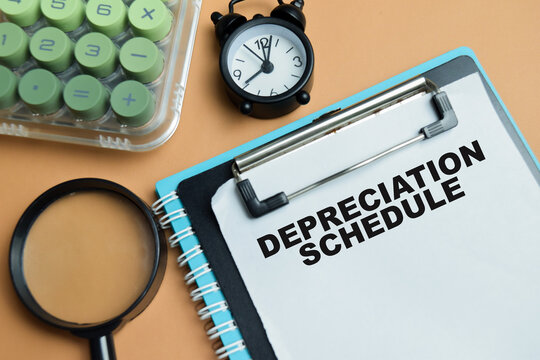 Concept of depreciation schedule write on clipboard isolated on table.