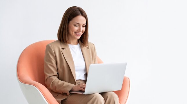 Smiling Young Businesswoman Working on Laptop Computer in Armchair on White Background