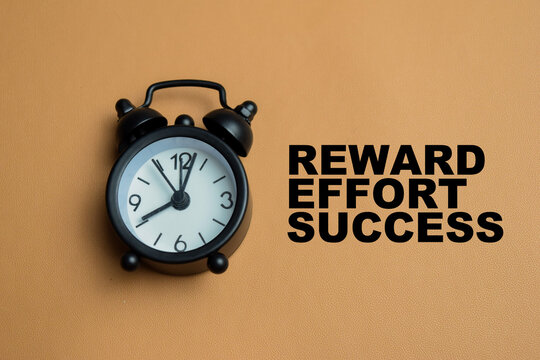 Concept of reward effort success write on book isolated on table.