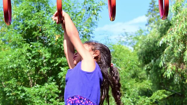 Latina girl crossing the monkey bars