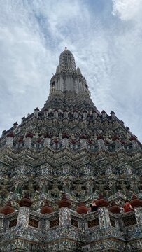 Historic Wat Arun Ratchawararam temple against clear blue sky in Bangkok, Thailand.