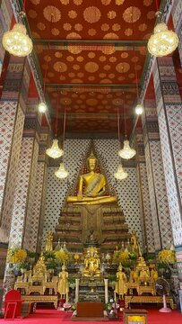 Golden Buddha statue enshrined inside the ordination hall of Buddhist temple in Bangkok, Thailand.