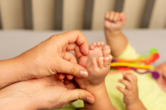 Mother Gently Tickling Baby Son Feet During Playtime